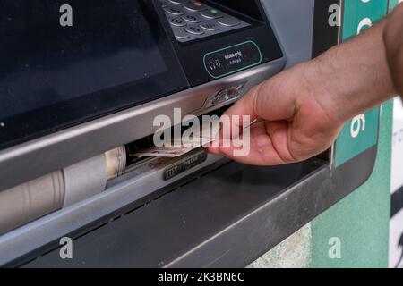 Mano uomo che ritira lira turca da bancomat, macchina automatica con mano di persona, business e concetto bancario, cliente che riceve denaro Foto Stock