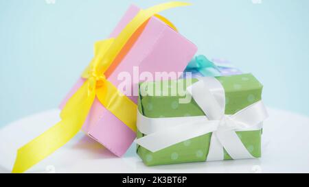 vista ravvicinata delle confezioni regalo confezionate in carta da imballaggio a pois su sfondo blu, immagine stock Foto Stock