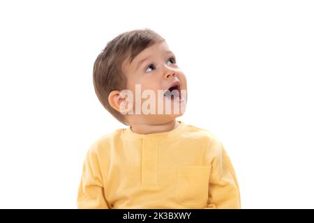 Bambino felice pensivo che guarda in su isolato su sfondo bianco Foto Stock