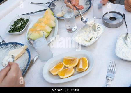 Tavolo turco Raki con melone, limone e antipasto, tradizionale alcool turco conosciuto come Rakı, chill con gli amici al ristorante, ristorante e idea pasto Foto Stock