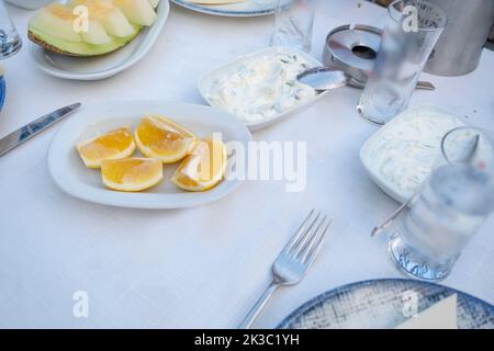 Tavolo turco Raki con melone, limone e antipasto, tradizionale alcool turco conosciuto come Rakı, chill con gli amici al ristorante, ristorante e idea pasto Foto Stock