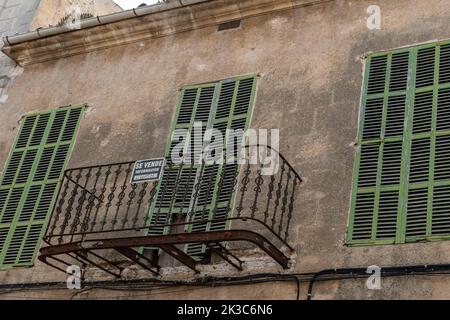 Felanitx, Spagna; settembre 21 2022: Facciata di un vecchio edificio in stato di rovina, con un cartello in vendita appeso sul suo balcone. Felanitx, isola di Mal Foto Stock