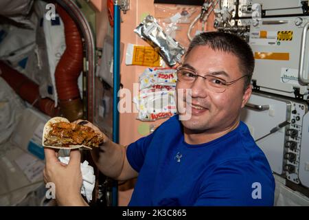 ISS - 16 agosto 2022 - Astronauta della NASA e spedizione 67 l'ingegnere di volo Kjell Lindgren si prepara a gustare un taco durante la cena a bordo dell'Internat Foto Stock
