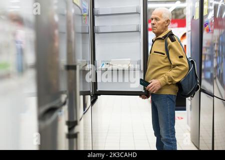 senor uomo pensionato acquistare frigorifero in showroom di elettrodomestici negozio Foto Stock