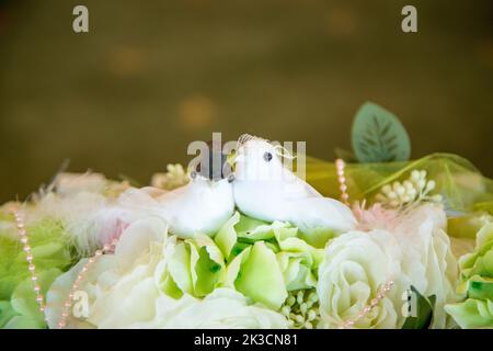 Un primo piano di uccelli artificiali sulla decorazione floreale di nozze Foto Stock