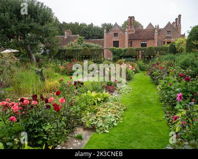 Chenies Manor House si affaccia sul restaurato Sunken giardino a dahlia tempo in un pomeriggio umido nel mese di settembre. Foto Stock