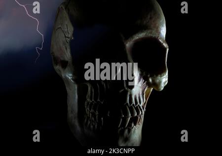 Cranio umano con illuminazione del bordo e lampo dietro Foto Stock