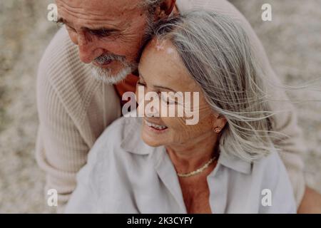 Coppia anziana rilassante e romantica nei pressi del mare autunnale. Foto Stock