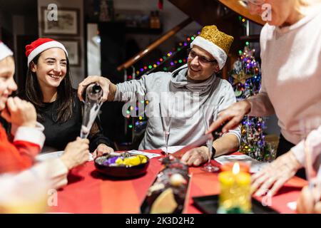 Allegra famiglia multi generazionale a Babbo Natale che celebra il natale Foto Stock