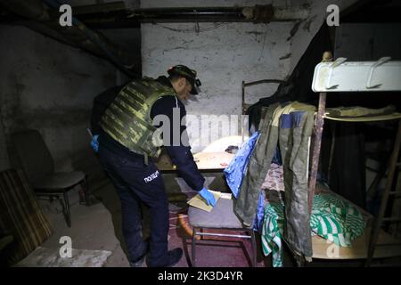 Non esclusivo: LYPTSI, UCRAINA - 24 SETTEMBRE 2022 - Un ufficiale di polizia esamina il seminterrato di un asilo dove gli invasori russi hanno vissuto prima del Foto Stock