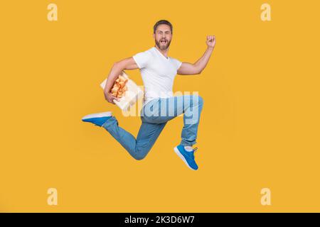 Uomo energico che corre veloce con la confezione regalo. Corriere regalo a mezz'aria. Consegna di regali e regali Foto Stock