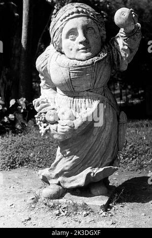 Zwergin mit Obstschürze, simbolisch für den Monat Settembre im Mirabellgarten a Salisburgo, circa 1960. Nana con grembiule di frutta, simbolica per il mese di settembre, intorno al 1960. Foto Stock