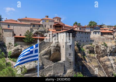 Bandiera greca a strisce bianche e blu vola di fronte all'ingresso del monastero di Great Meteoron. Meteora, Grecia Foto Stock