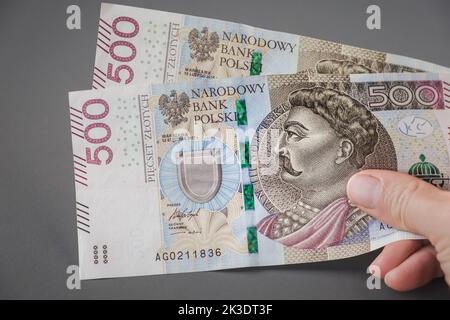 Pagare, dare, ricevere denaro polacco. Mano con banconota da 500 zloty. Stipendio Polonia. Foto Stock