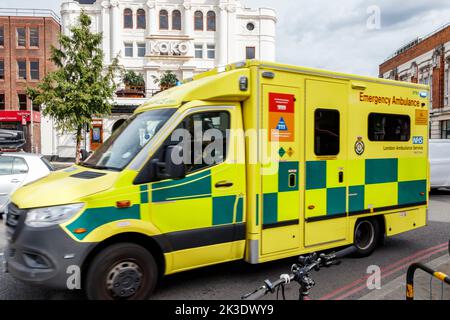 Un'ambulanza di emergenza che accelera sulla relativa strada ad un incidente, Camden, Londra, Regno Unito Foto Stock