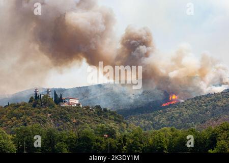 Elicottero contro il fuoco selvaggio durante il vento forte e la siccità vicino al castello di Miren in Slovenia Foto Stock