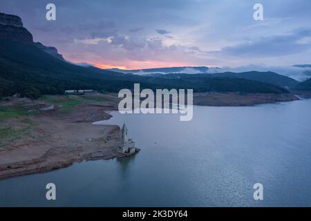 Campanile di Sau completamente esposto durante la siccità del 2022. Alba rossa nella palude (Osona, Barcellona, Catalogna, Spagna) ESP: Campanario de Sau Foto Stock