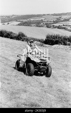 Contadino e due ragazzi in quad, High Bickington, North Devon, Inghilterra, Regno Unito. Foto Stock