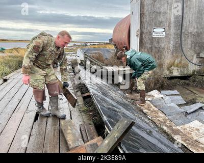 Newtok, Stati Uniti. 22nd Set, 2022. I soldati degli Stati Uniti con la Guardia Nazionale dell'Alaska assistono i residenti locali nella pulizia delle proprietà danneggiate durante l'operazione Merbok Response, 22 settembre 2022 a Newtok, Alaska. I remoti villaggi costieri subirono danni dai resti di Tifone Merbok che causarono inondazioni in oltre 1.000 miglia di costa dell'Alaska. Credit: 1st Lt. Balinda o'Neal/US Army/Alamy Live News Foto Stock