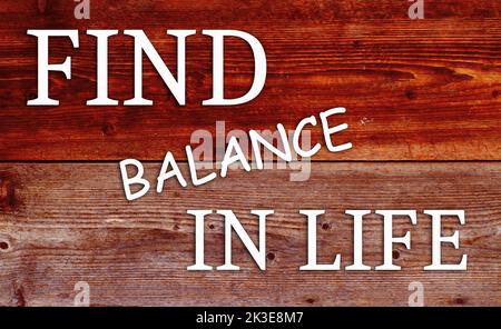 Citazione motivazionale ispirazione trovare equilibrio în vita, su sfondo di legno. Foto Stock