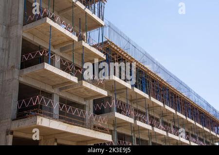 Casa monolitica in costruzione. Elementi di cassaforma in legno per la colata di calcestruzzo in cantiere. Montaggio del cavalletto telescopico per l'installazione Foto Stock