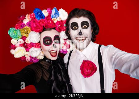 Closeup foto di bella coppia demone uomo donna abbraccio prendere selfie emozionante viaggio latino ottobre indossare abito nero costume morte sospenditori con archetto roses Foto Stock