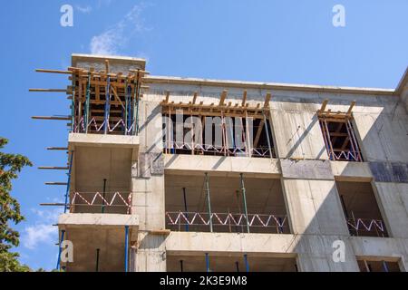 Casa monolitica in costruzione. Elementi di cassaforma in legno per la colata di calcestruzzo in cantiere. Montaggio del cavalletto telescopico per l'installazione Foto Stock