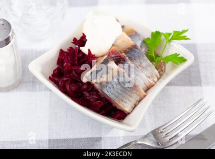 Pezzi di aringa con barbabietola serviti sul piatto Foto Stock