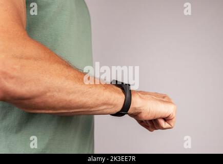 Con l'orologio nero intelligente per il fitness, braccialetto sulla mano degli uomini. Foto di alta qualità Foto Stock