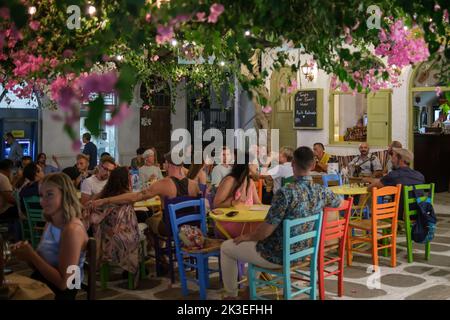 IOS, Grecia - 11 settembre 2022 : pittoresca terrazza all'aperto con sedie colorate e locali che suonano musica tradizionale dal vivo in iOS cicladi Grecia Foto Stock