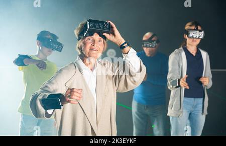 Nonna stupita in VR club con la famiglia Foto Stock
