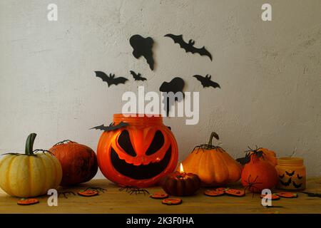 Buon Halloween! Jack di secchio di caramelle lanterne, zucche, ragni neri, pipistrelli e fantasmi decorazioni su sfondo rustico in sala da sera. Hallo spettrale Foto Stock