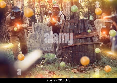 Squadre che giocano a paintball all'aperto Foto Stock