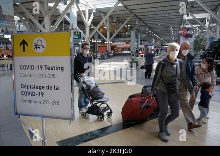 Richmond, Canada. 26th Set, 2022. I viaggiatori con maschere facciali oltrepassano un cartello che indica la posizione per il test COVID-19 all'aeroporto internazionale di Vancouver a Richmond, Canada, il 26 settembre 2022. Il governo federale canadese ha annunciato Lunedi la rimozione di tutte le restrizioni di ingresso COVID-19, così come test, quarantena, e requisiti di isolamento per chiunque entri in Canada, a partire dal 1 ottobre. Credit: Liang Sen/Xinhua/Alamy Live News Foto Stock