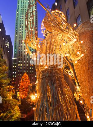 Decorazione d'angelo natalizio del Rockefeller Center illuminata di notte nei giardini del canale. New York City, Midtown Manhattan, Stati Uniti Foto Stock