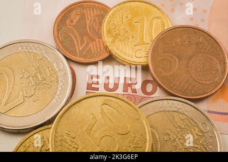 Primo piano di monete in euro assortite in aggiunta a una banconota da 10 euro. Foto Stock