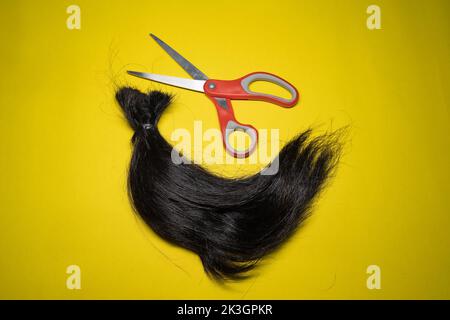 Una ciocca di capelli e forbici Foto Stock