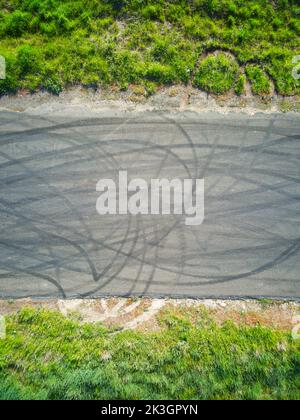 Contrassegni pneumatici sulla vista aerea della strada che mostrano i modelli di contrassegni di slittamento e erba verde sul bordo della strada, Victoria, Australia. Foto Stock