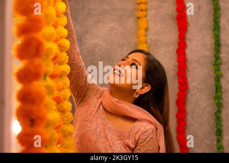 Donna decorazione ufficio da ghirlanda di fiori in occasione di Diwali Foto Stock