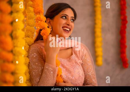 Donna decorazione ufficio da ghirlanda di fiori in occasione di Diwali Foto Stock