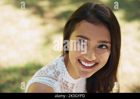 Bellezza naturale. Una bella giovane donna seduta fuori nel parco. Foto Stock