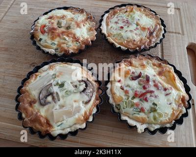 Quattro loraine quiche fatte in casa in ramekins Foto Stock