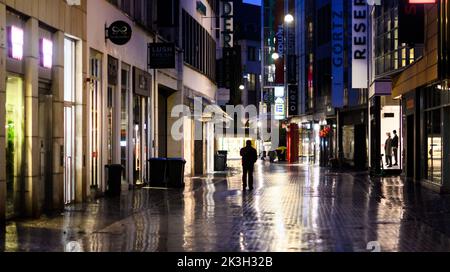 Hannover, Germania. 27th Set, 2022. Un passerby cammina per il centro della città di mattina presto. Le normative sul risparmio energetico introdotte dai governi federali a causa della crisi energetica non portano a zone buie del centro. I cartelloni luminosi devono essere spenti dalle 17:10 alle 22:4 del giorno successivo. La finestra del negozio e l'illuminazione stradale, tuttavia, sono esenti da ordinanze. Credit: Julian Stratenschulte/dpa/Alamy Live News Foto Stock