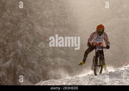 Sofia, Bulgaria - 22 gennaio 2022: Il ciclista percorre una discesa in bicicletta durante una gara estrema di mountain bike sulla neve sul monte Vitosha. Foto Stock