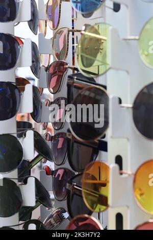 Molti occhiali da sole sulla strada stand a Heidelberg, Germania. Gruppo di occhiali da sole colorati sullo scaffale del negozio ottico. Occhiali, protezione solare Foto Stock