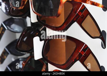 Molti occhiali da sole sulla strada stand a Heidelberg, Germania. Gruppo di occhiali da sole colorati sullo scaffale del negozio ottico. Occhiali, protezione solare Foto Stock