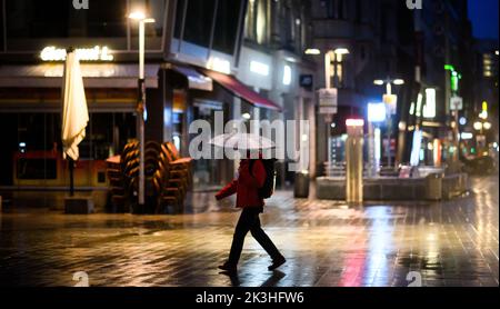 Hannover, Germania. 27th Set, 2022. Un passerby cammina per il centro della città di mattina presto. Le normative sul risparmio energetico introdotte dai governi federali a causa della crisi energetica non portano a zone buie del centro. I cartelloni luminosi devono essere spenti dalle 17:10 alle 22:4 del giorno successivo. La finestra del negozio e l'illuminazione stradale, tuttavia, sono esenti da ordinanze. Credit: Julian Stratenschulte/dpa/Alamy Live News Foto Stock