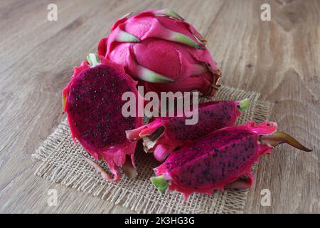 Frutto del drago, in turco si taglia il frutto del drago viola o pitaya, detto “ejder meyvesi”. Primo piano, vista seduta. Foto Stock