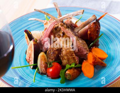 Costolette di montone arrosto con fichi, verdure, demi-glace e vino rosso Foto Stock