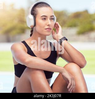 Relax, fitness e runner con musica in cuffia per lo sport all'aperto e pausa relax. Benessere, motivazione e allenamento donna godendo del tempo di riposo Foto Stock